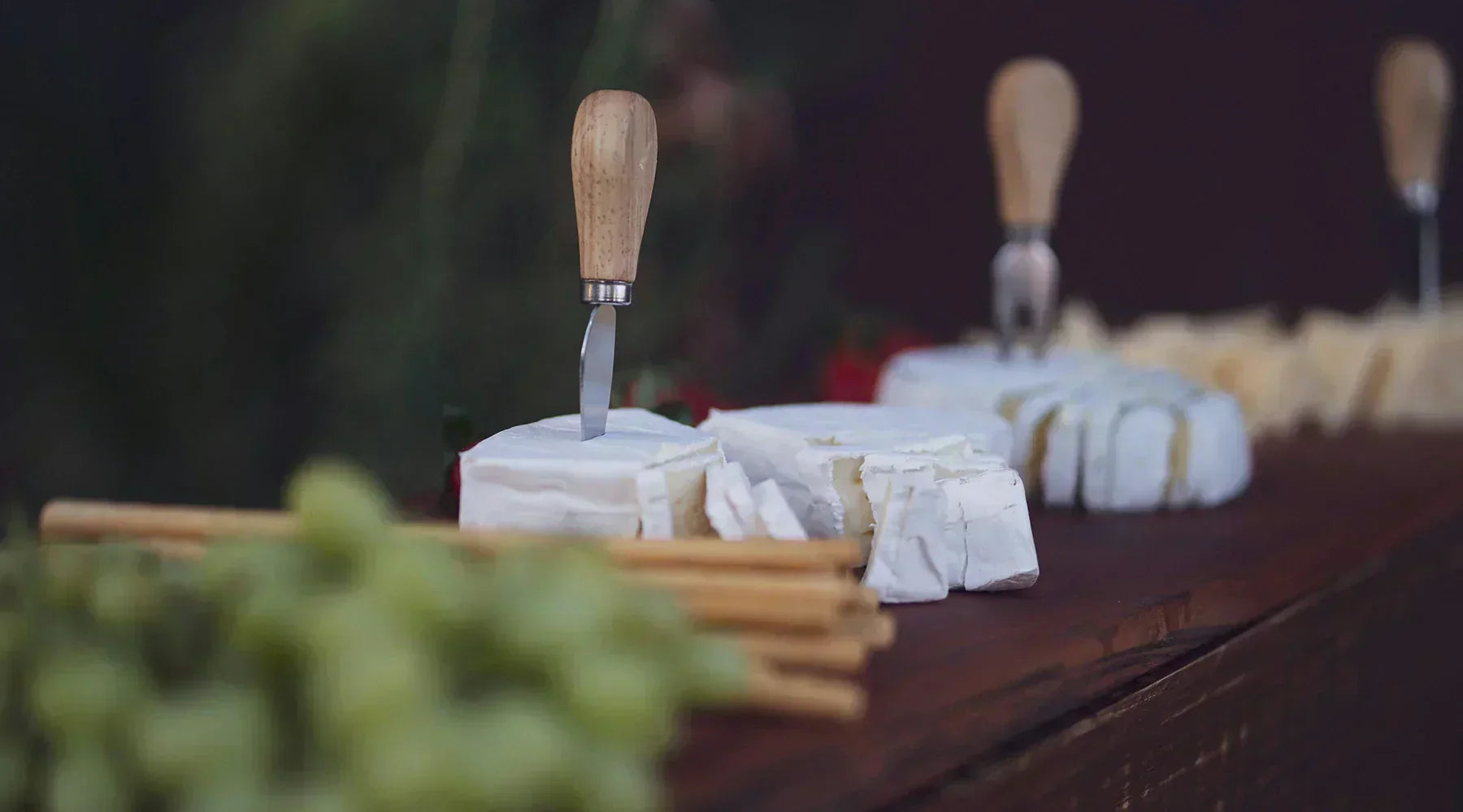 a rustic wood table with fruit and cheeses on it